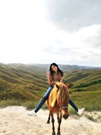 Portrait of young woman standing against mountain