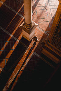 High angle view of man walking on footpath in city