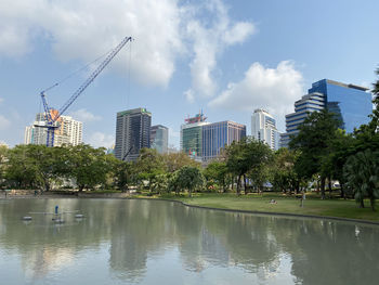 View of modern buildings by canal against sky