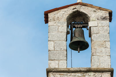 Low angle view of bell tower against blue sky