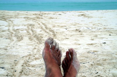 Low section of woman relaxing on beach