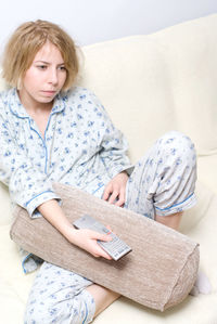 Portrait of young woman reading book at home