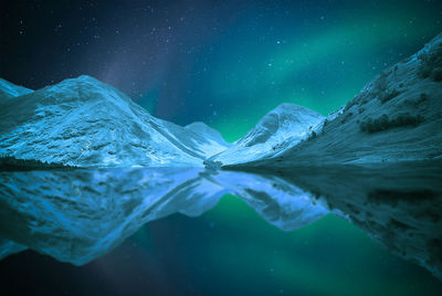 Scenic view of snowcapped mountains against sky at night