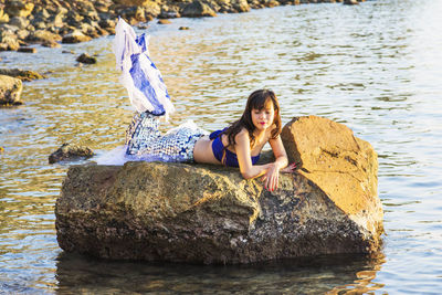 Woman standing on rock by lake