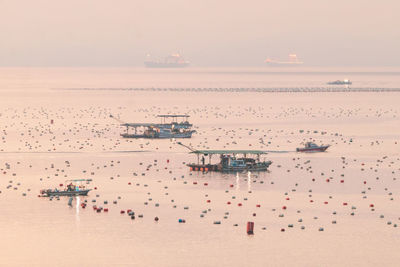 People at beach against sky during sunset