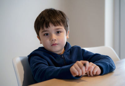 Portrait of boy sitting at home