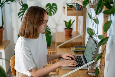 Young woman working on laptop from home.