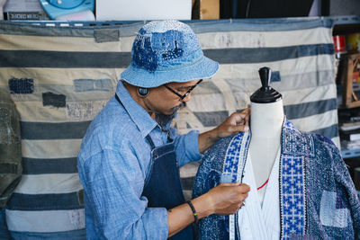 Man working over fabric on table