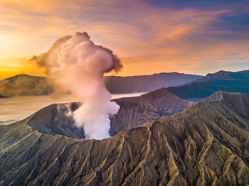 Smoke emitting from volcanic mountain against sky