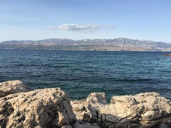 Scenic view of sea and mountains against sky