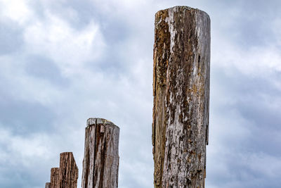 Low angle view of wooden post against sky