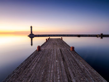 Pier over sea against sky during sunset