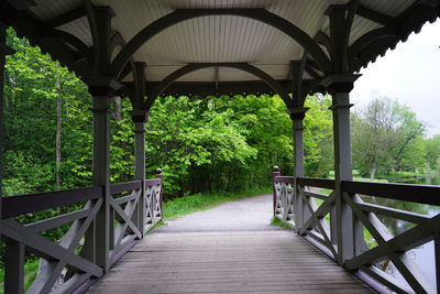 Empty footbridge against trees