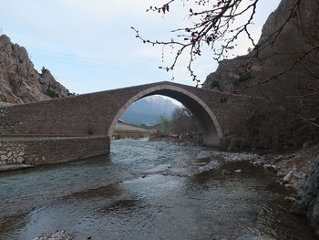 Arch bridge over river against sky