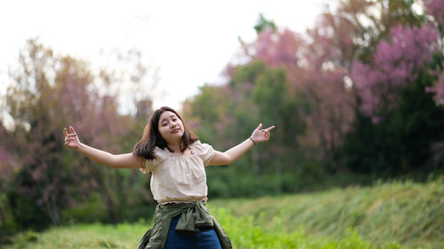Asian girl smiles mischievously and turns towards the camera during a nature tour,
