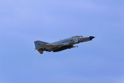 Low angle view of airplane flying against clear blue sky