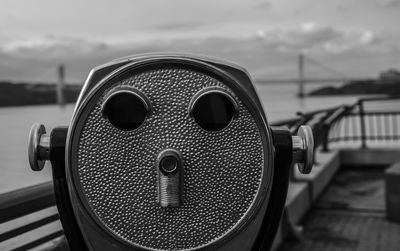 Close-up of coin-operated binoculars against sea