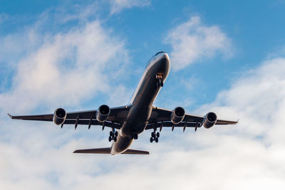 Low angle view of airplane flying against sky