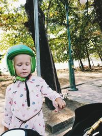 Cute girl sitting on tree trunk