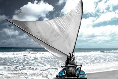 Boats in sea against cloudy sky