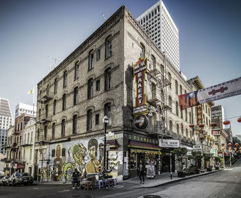 Street by buildings against sky in city