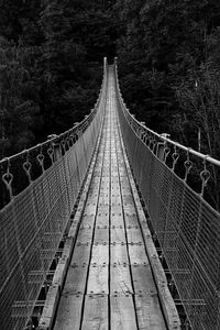 Rear view of man walking on footbridge