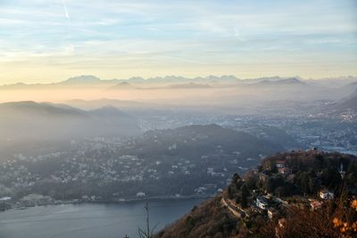 Aerial view of city by sea against sky