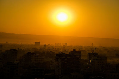 Silhouette buildings against sky during sunset