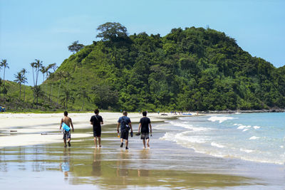 People walking on beach against sky