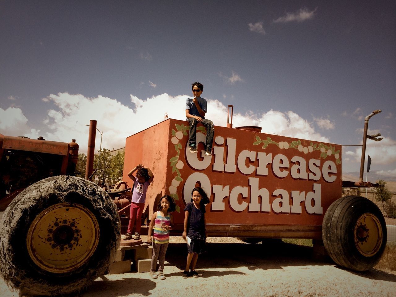 sky, lifestyles, men, leisure activity, cloud - sky, text, communication, full length, western script, rear view, standing, casual clothing, outdoors, transportation, day, land vehicle, built structure, person