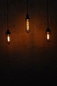 Low angle view of illuminated pendant light hanging from ceiling