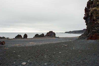 Rocks on beach against sky