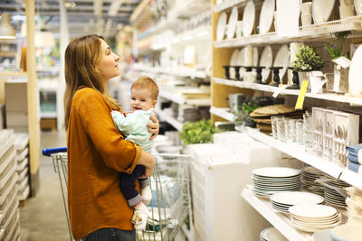 Rear view of mother with daughter standing at store