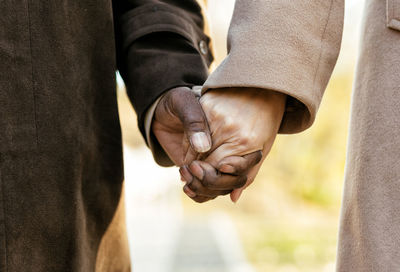 Low section of couple holding hands