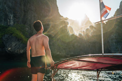 Rear view of shirtless man standing on mountain