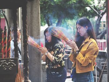 Side view of women praying at temple