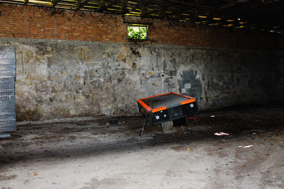 Empty chairs and tables against wall in old building