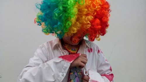 Close-up of boy wearing costume standing against wall