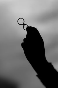 Close-up of human hand against sky