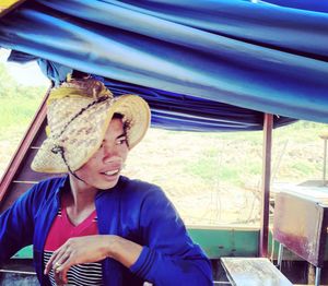 Portrait of young woman sitting on wall