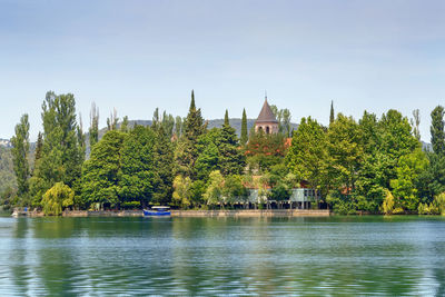 Scenic view of trees by lake against sky