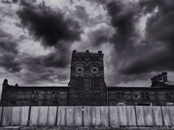 Low angle view of old building against cloudy sky