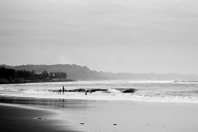 People on beach against sky