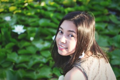 Portrait of smiling woman by lotus water lily