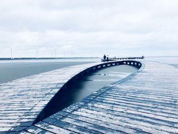 Bridge over sea against sky during winter