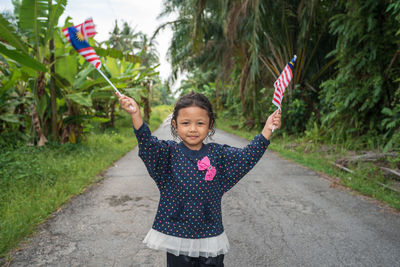 Portrait of smiling girl standing by plants