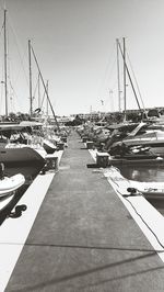 Sailboats moored at harbor against clear sky