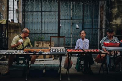 Full length of friends sitting on table