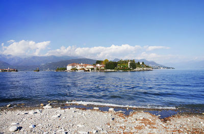 Scenic view of sea by buildings against sky