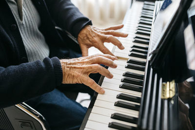 Crop view of senior man playing piano